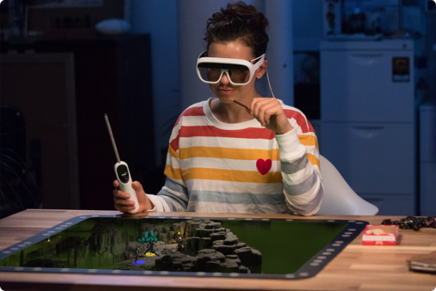 Spieler mit Wand-Controller und AR-Brille vor Tilt-Five-Spielbrett.