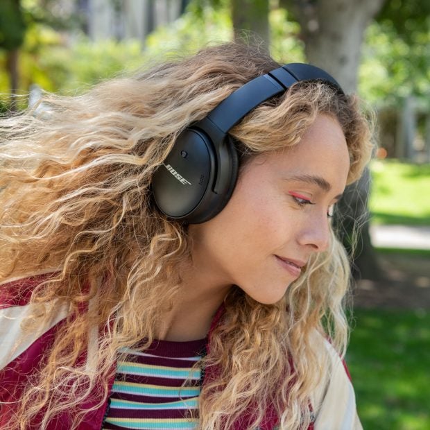 Eine Frau trägt die Bose Quietcomfort Headphones