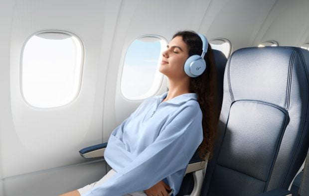 Eine Frau trägt den Souncore Space One im Flugzeug.