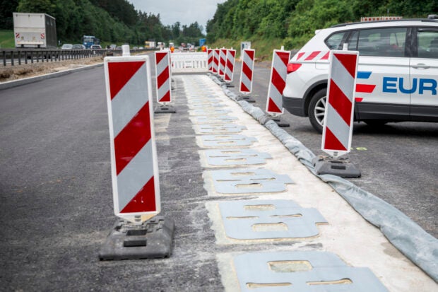 Auf einer Baustelle auf der Autobahn sind Spulen zum kabellosen Laden von E-Autos zu erkennen.