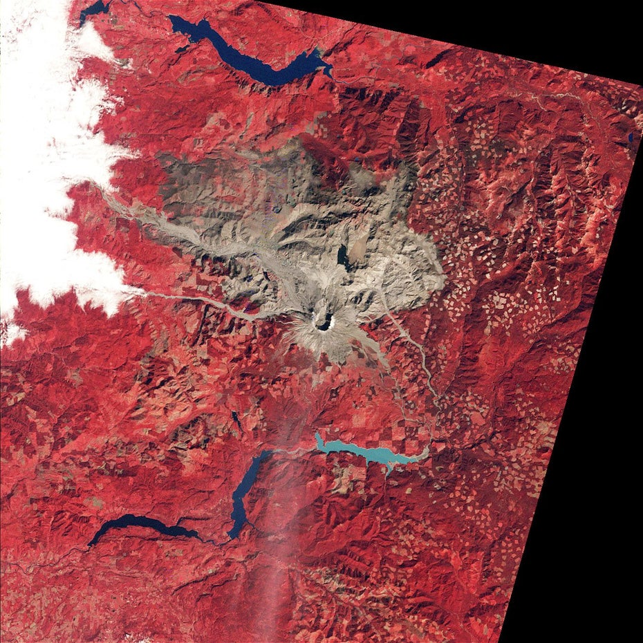 Auf rotem Untergrund sind in grau-braun der Mount St. Helens und die Folgen seines Ausbruchs zu sehen.