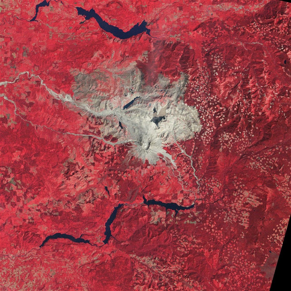 In grau-braun sind der Mount St. Helens und die ihn umgebende Landschaft auf rotem Untergrund zu sehen.
