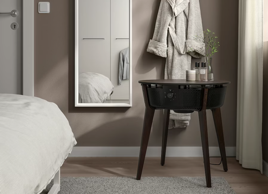 Ikea Smart Home Starkvind: Ein schwarzer Tisch mit Drahteinsatz steht in einer dunkel gehaltenen Schlafzimmereinrichtung