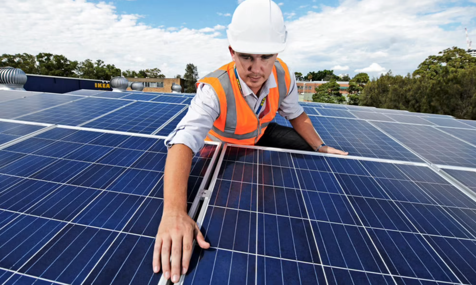 Ein Ikea-Mitarbeiter arbeitet auf einem Dach an einer Solaranlage
