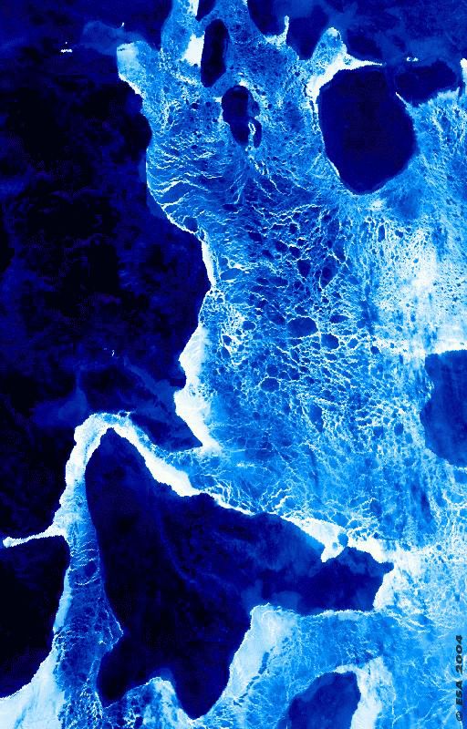 Die bearbeitete Nachtaufnahme der Arktis zeigt die Eisschichten als weiß-blau leuchtende Bereiche, die Schneemassen dazwischen sind dunkelblau bis schwarz.