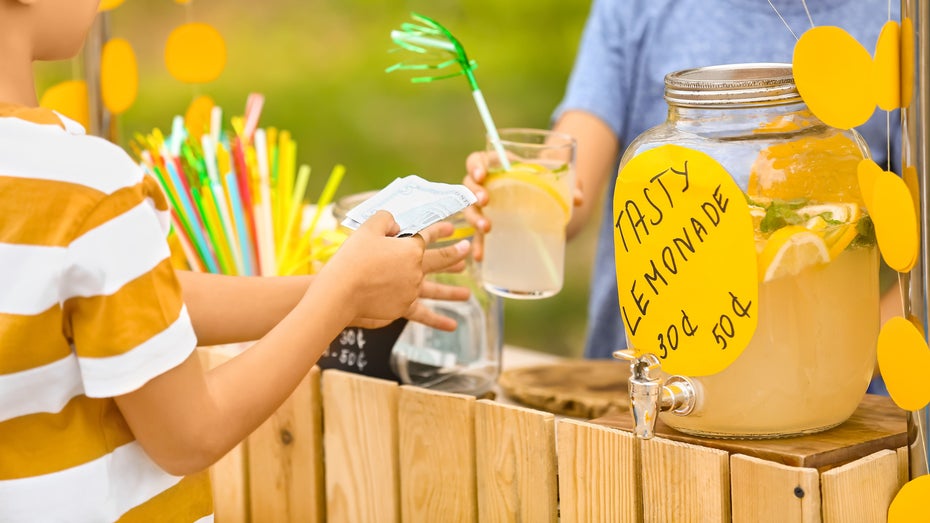 Junge kauft Limonade von einem anderen Kind 