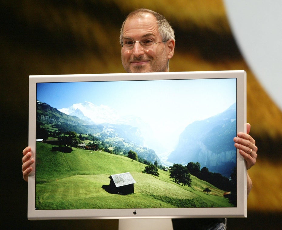 Steve Jobs hält einen Bildschirm mit 30" Cinema HD display, auf dem eine Berglandschaft zu sehen ist.