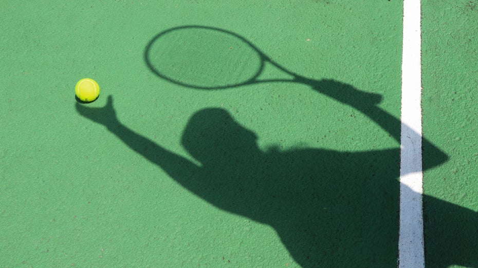 Schatten einer Person mit Tennisschläger und Tennisball
