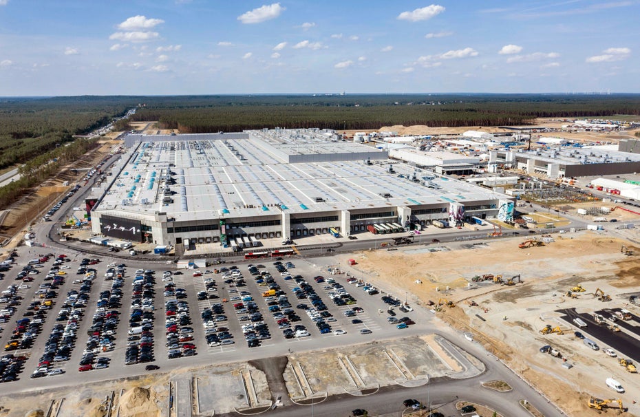 Die Tesla-Fabrik in Grünheide ist von oben zu sehen, links im Bild befinden sich viele Autos.