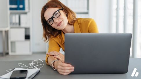 Eine Frau sitzt am Schreibtisch vor ihrem Laptop und schaut freundlich in die Kamera. Bildquelle: contrastwerkstatt/Adobe Stock