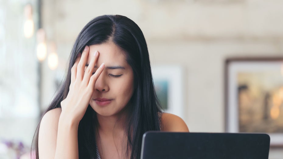 Frau sitzt genervt vor Laptop