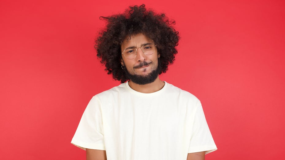 Symbolbild: Ein junger Mann schaut nachdenklich 